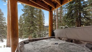 A hot tub with a wooden frame and a view of snow-covered trees and mountains. - 14mcbr3 (Breckenridge)