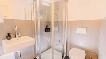 Habitación Confort doble | Baño | Ducha, secador de pelo, toallas y jabón