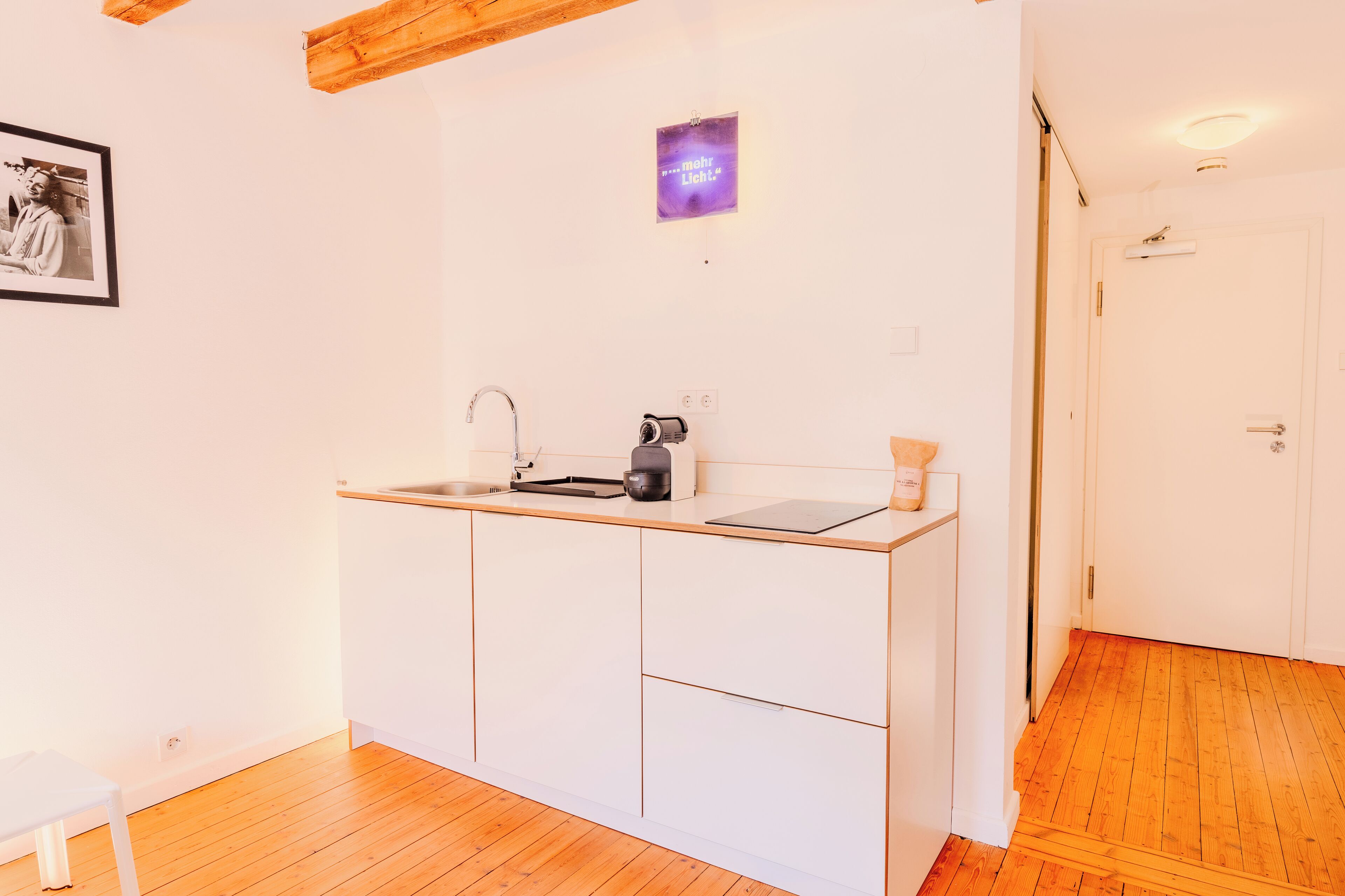 Una cocina compacta con encimera de madera, un lavamanos y un mueble pequeño.