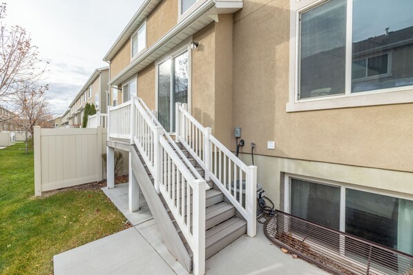 A residential building with a front porch, a staircase, and a garage door.