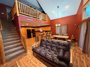 A spacious living area with a wooden staircase, a dining area with a large wooden table, and a kitchen with wooden cabinets. - Spacious 5-bedroom, 4 Bathroom House - cozy Anglers Retreat (Onamia)