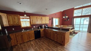 A spacious kitchen with wooden cabinets, a dishwasher, and a large island.