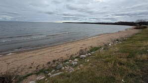 A beach with a rocky shoreline and a grassy area.