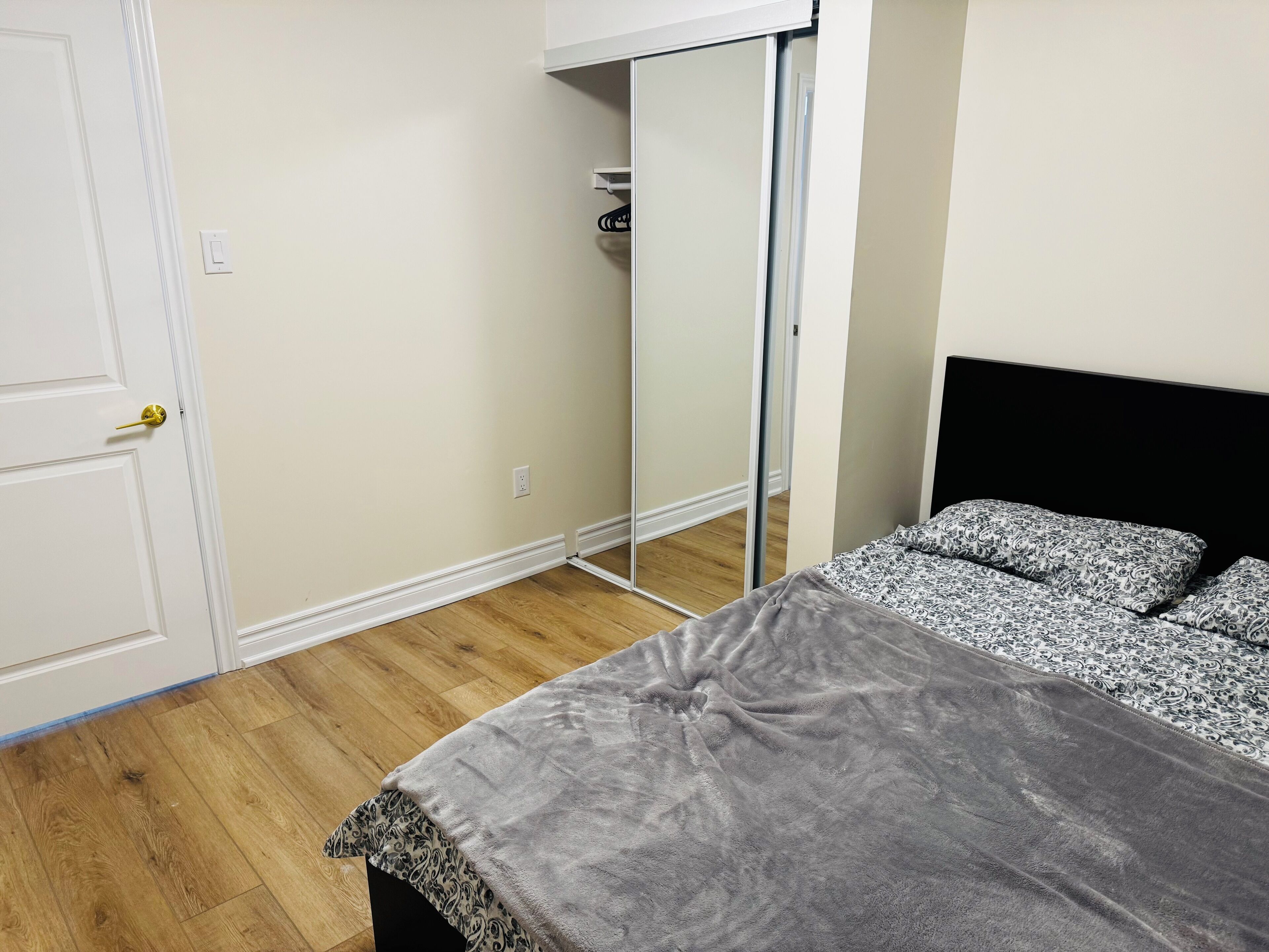 Ein Schlafzimmer mit Bett, Schrank und Tür.