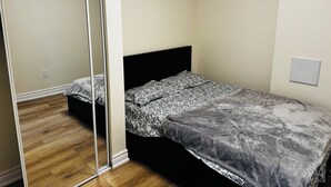 Un dormitorio con cama, armario y un interruptor de luz en la pared.