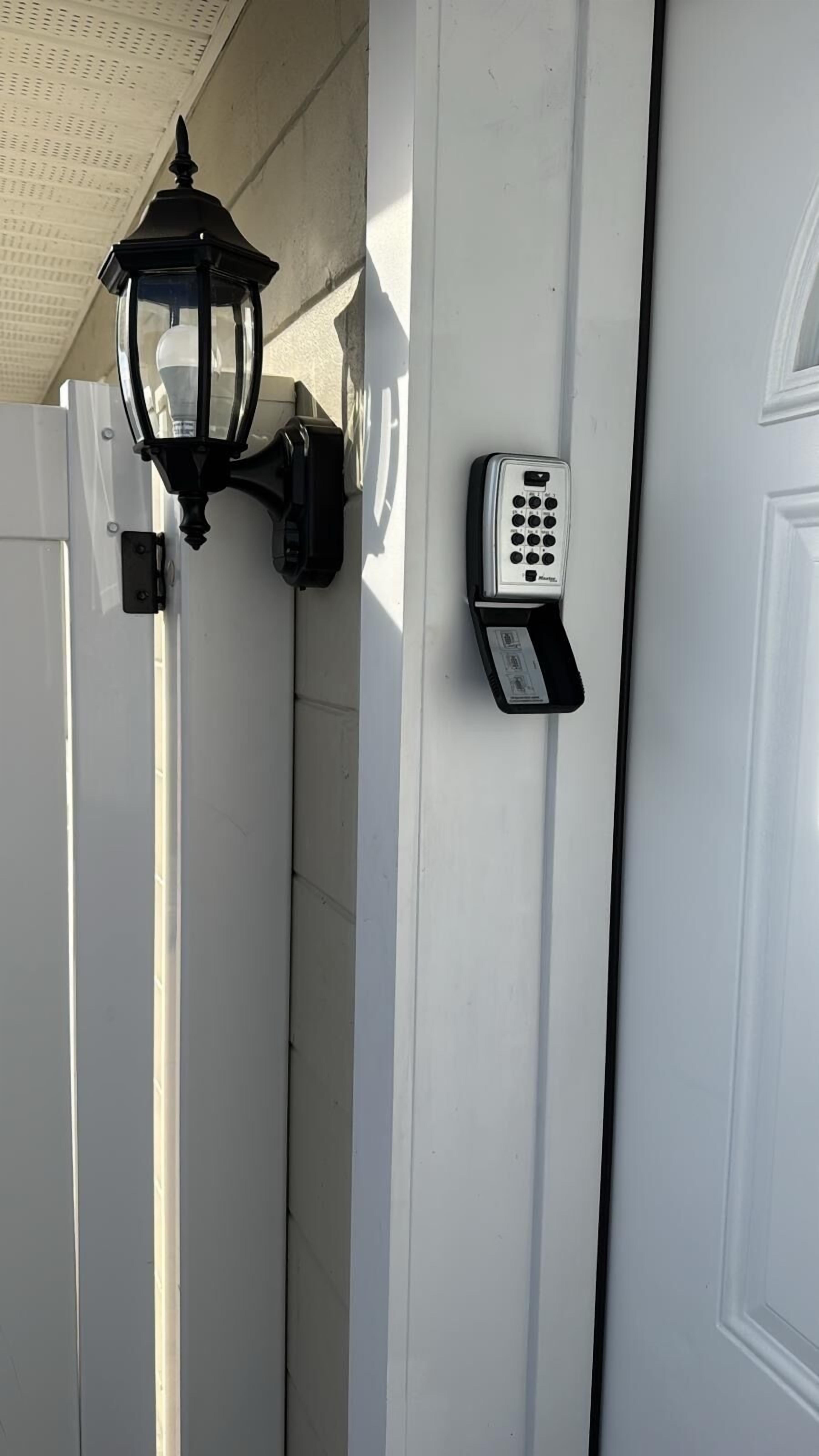 A door with a wall-mounted security keypad and a traditional lantern.