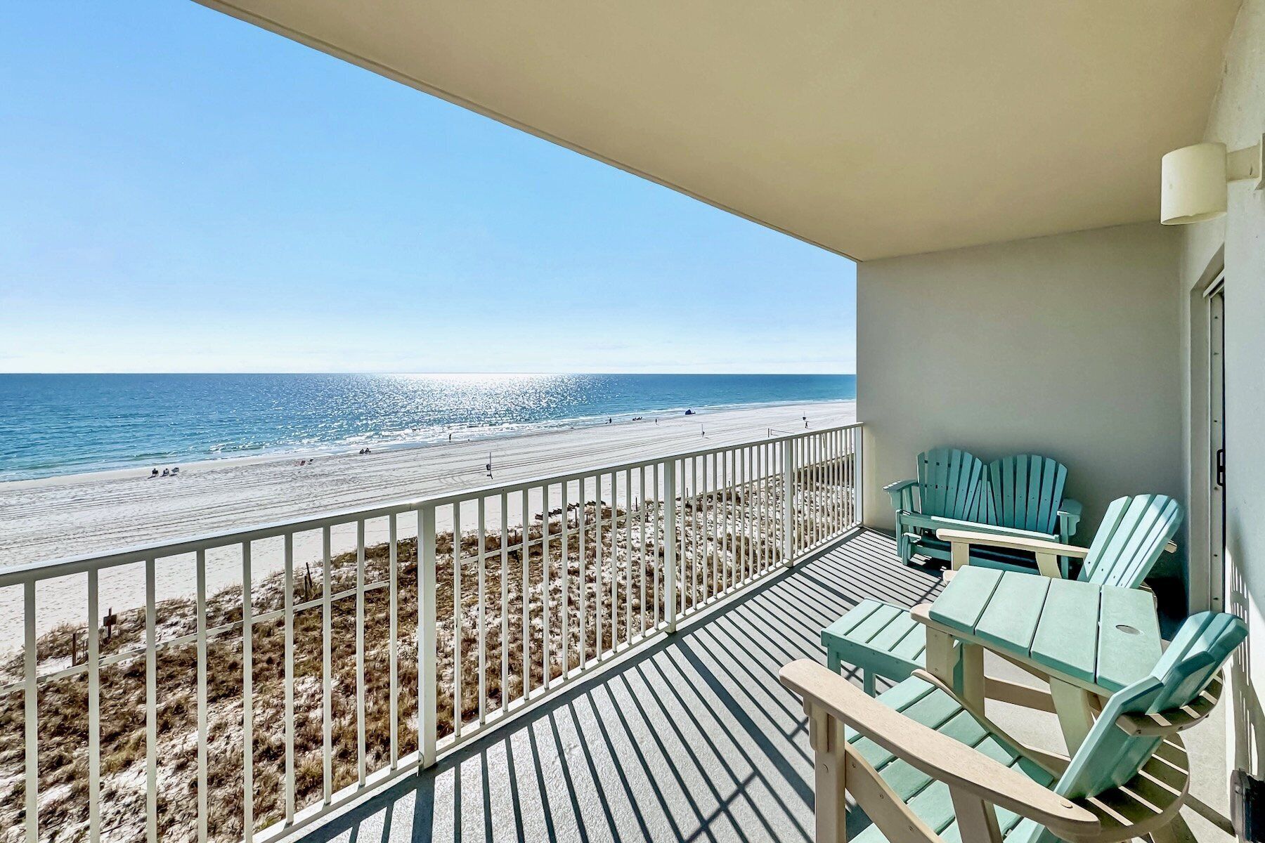 A balcony with a view of the beach and ocean.