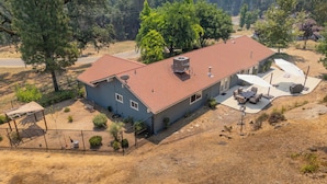 A two-story house with a red roof, a fenced backyard, and a satellite dish. - Moonrise Retreat, SPA, Near Yosemite & Bass Lake (Oakhurst)