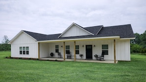 A single-story house with a covered porch, a front door, and a small front yard.