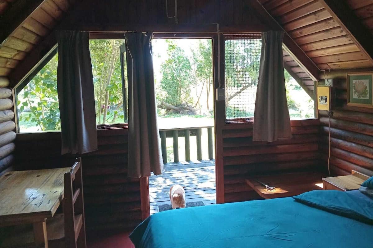 Una cabaña con habitación en el entrepiso, terraza de madera y vistas al exterior.