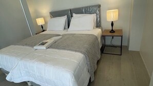 A neatly arranged bedroom with a bed, two bedside tables with lamps, and a slanted ceiling. - Spacious 4-bedroom house in wonderful San Juan with AC close to beachfront (San Juan)