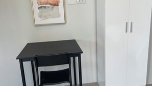 A room with a black table and a white wardrobe, an air conditioner above the table, and a framed artwork on the wall. - Spacious 4-bedroom house in wonderful San Juan with AC close to beachfront (San Juan)