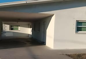 Ein modernes Gebäude mit überdachtem Parkplatz und einem Fenster an der Seite.