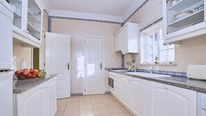 A kitchen with white cabinets, a granite countertop, and a tiled floor. - Villa sunset Solarenga is quiet villa w / private pool 10min from the beach (Lagoa)