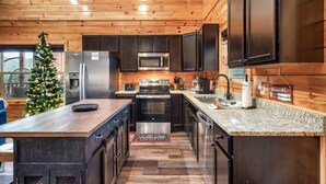 Eine moderne Küche mit Holzschränken, Edelstahlgeräten und einer Granitabdeckung.