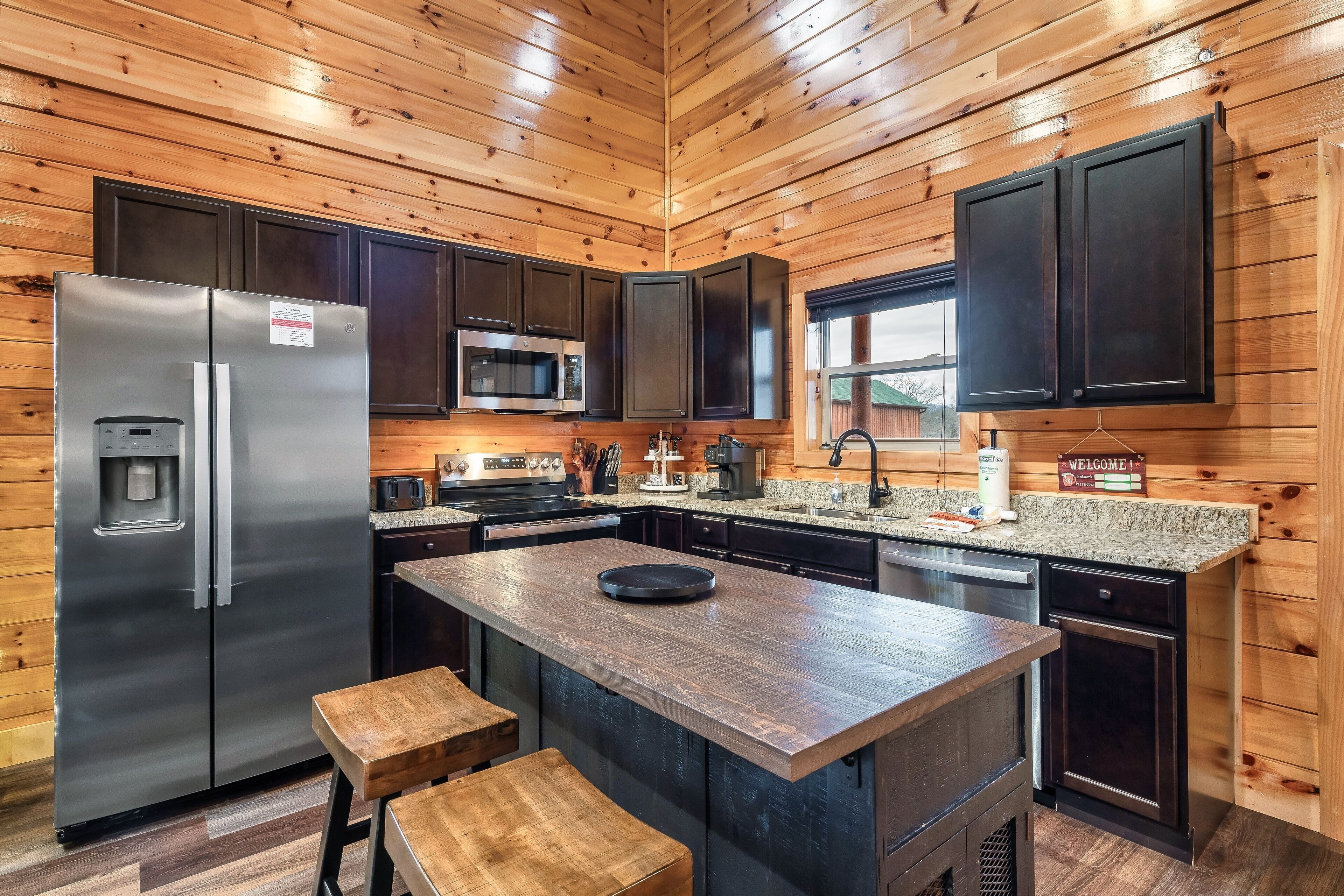 A modern kitchen with wooden paneling, stainless steel appliances, and a central island.