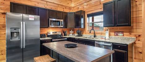 A modern kitchen with wooden paneling, stainless steel appliances, and a central island.