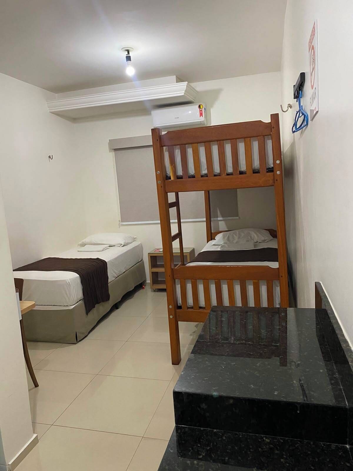 Una habitación pequeña con literas, una mesita y una ventana.