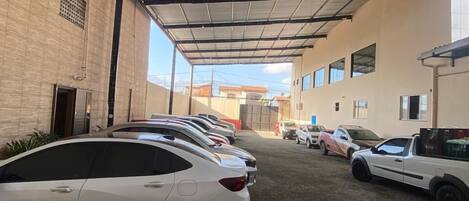 A covered parking area with multiple cars parked.