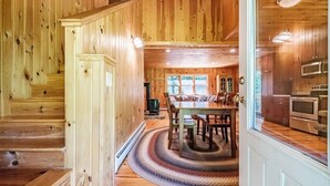 Un interior de madera con comedor, cocina y escalera.