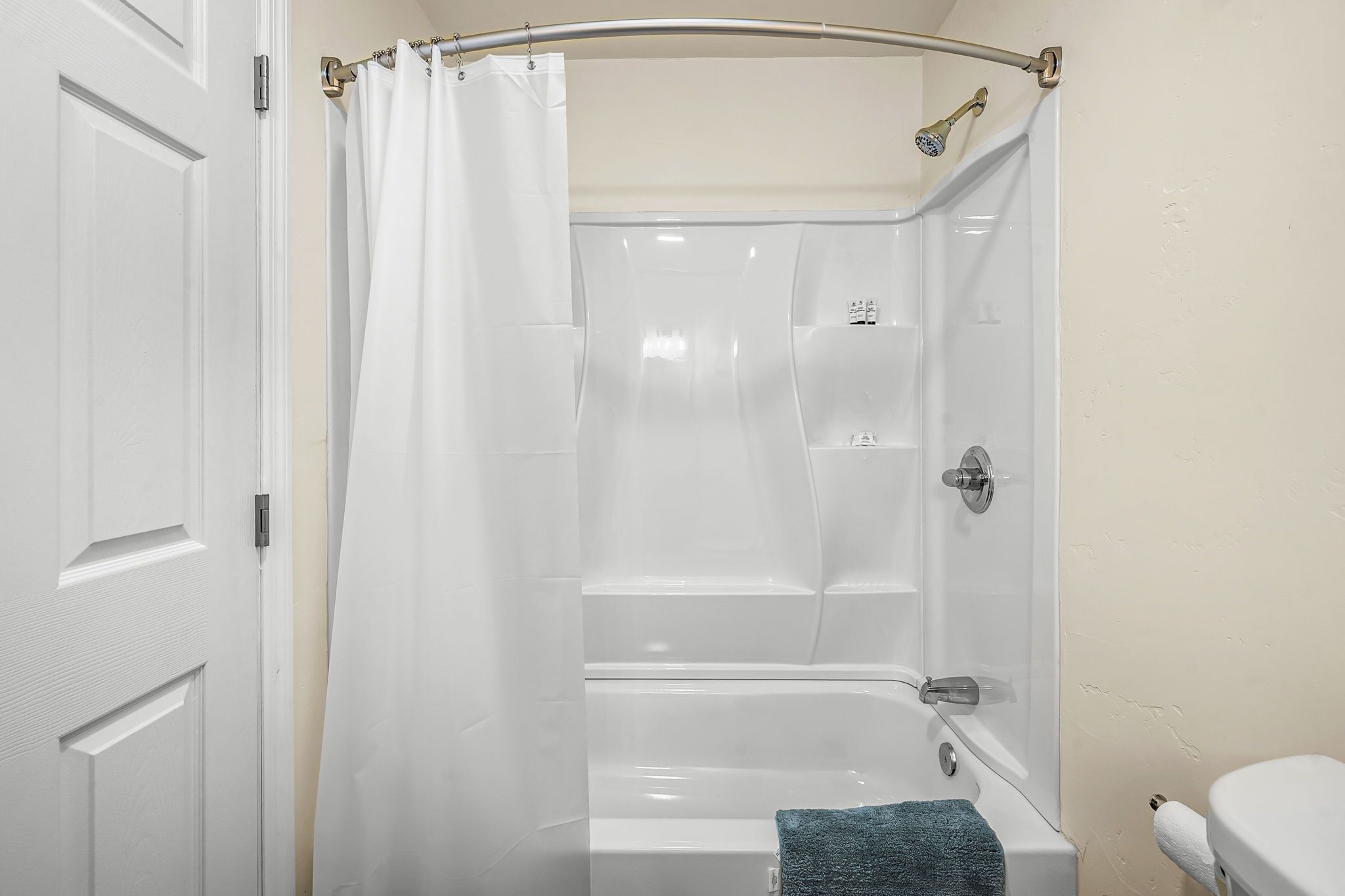Une salle de bain avec une douche, des toilettes et un porte-serviettes.