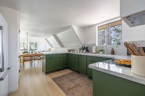 A modern kitchen with green cabinets, a white countertop, and a skylight. - Cozy 3BR A-Frame Lake Views Family Friendly (Sedona)