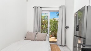 Une chambre à coucher avec un lit, une télévision et une vue sur l’extérieur.