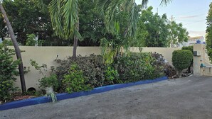 Un camí pavimentat que condueix a un edifici amb una paret beix i detalls blaus.