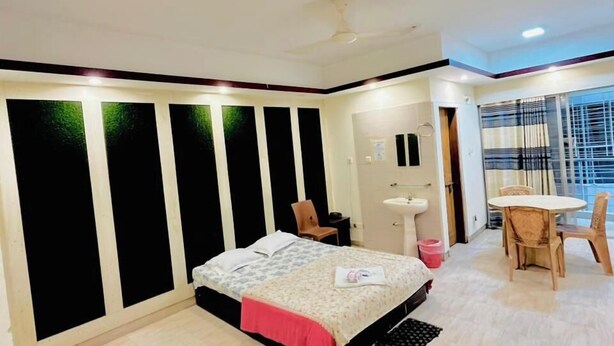 A modern bedroom with a bed, a small table, and a chair. - Hotel The Grand Sandy Cox's Bazar (Cox's Bazar)