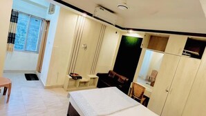 A modern bedroom with a large bed, a wardrobe, a desk, and a window with curtains. - Hotel The Grand Sandy Cox's Bazar (Cox's Bazar)