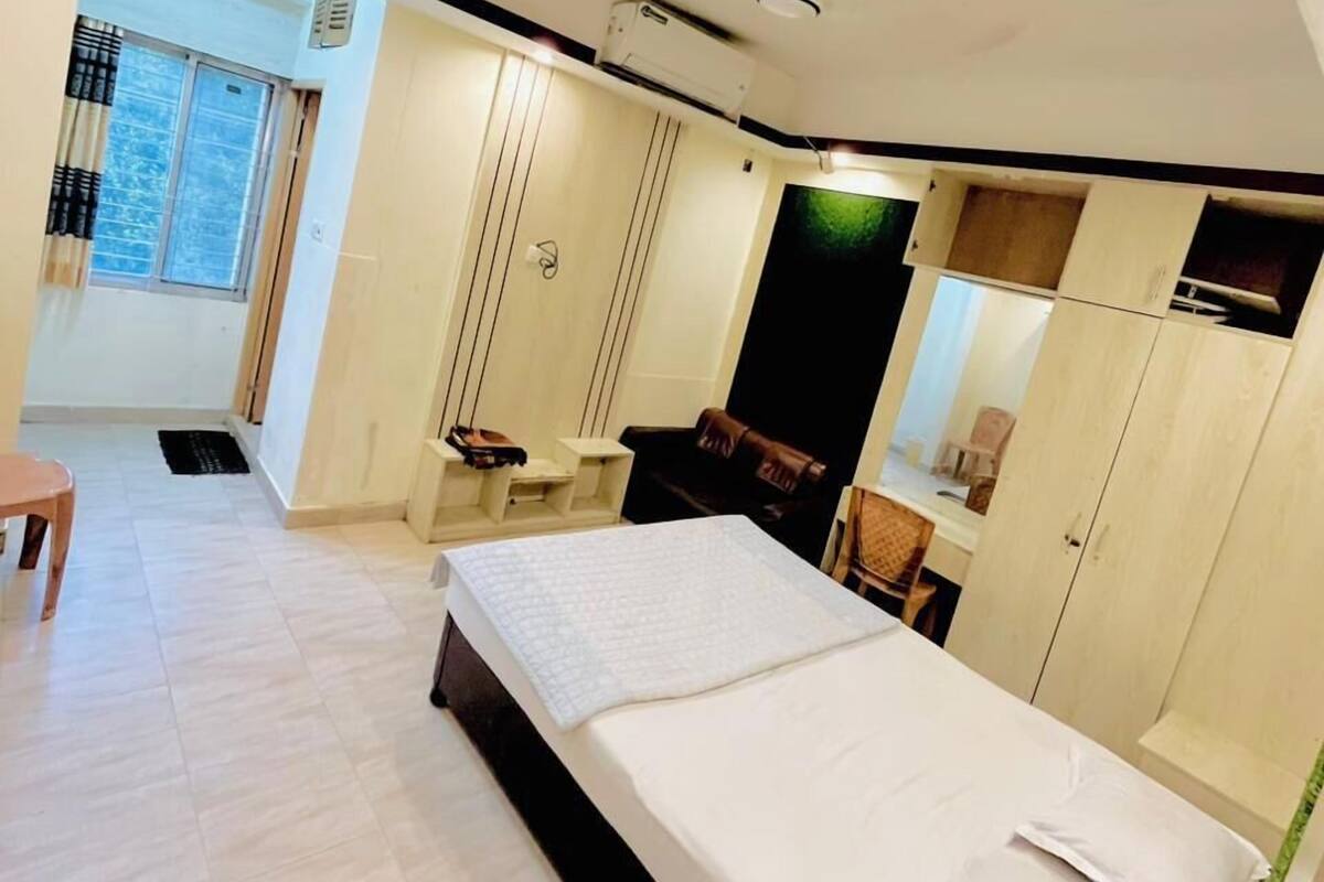 Ein modernes Schlafzimmer mit einem großen Bett, einem Kleiderschrank, einem Schreibtisch und einem Fenster mit Vorhängen.