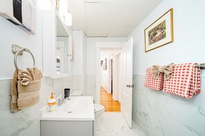 Une salle de bain équipée d’un lavabo, de toilettes et d’un porte-serviettes.