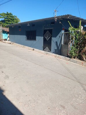 A building with a dark blue exterior, a metal gate, and a small window.
