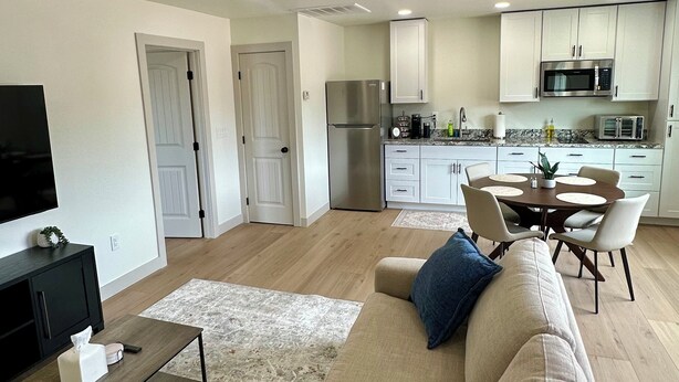 Un salon moderne avec un canapé beige, une table basse et un téléviseur à écran plat.