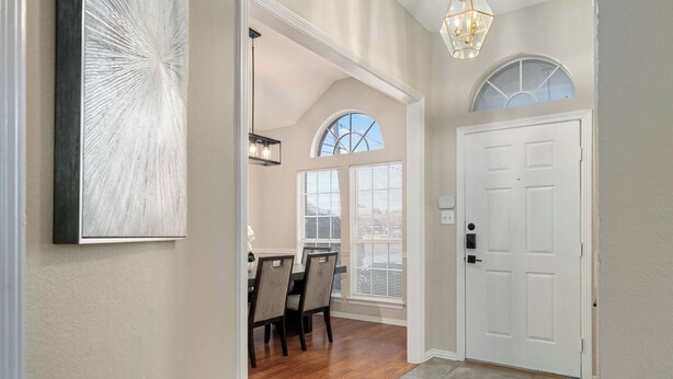 A hallway with a dining area, a white door, and a large window with a view. - Suburban Retreat Central to Dallas, Plano & Frisco (Dallas)