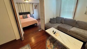 A compact living space with a bed, a sofa, a coffee table, and a patterned rug. - Perfect and Spacious Hudson Valley Escape! (Cornwall)