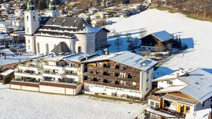 A snow-covered town with a prominent church, a large wooden building, and residential houses.