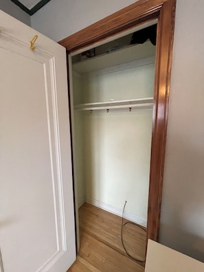 A room with a wooden door, a white wall, and a wooden floor. - Mid-Term Rental - Over 30 Days - Saint Paul near colleges (Saint Paul)