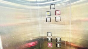 An elevator interior with buttons for floors 0 to 4, a wheelchair accessibility button, and a button with a symbol indicating a specific function. - Premium Hotel M Shri near Mahakal Temple (Ujjain)