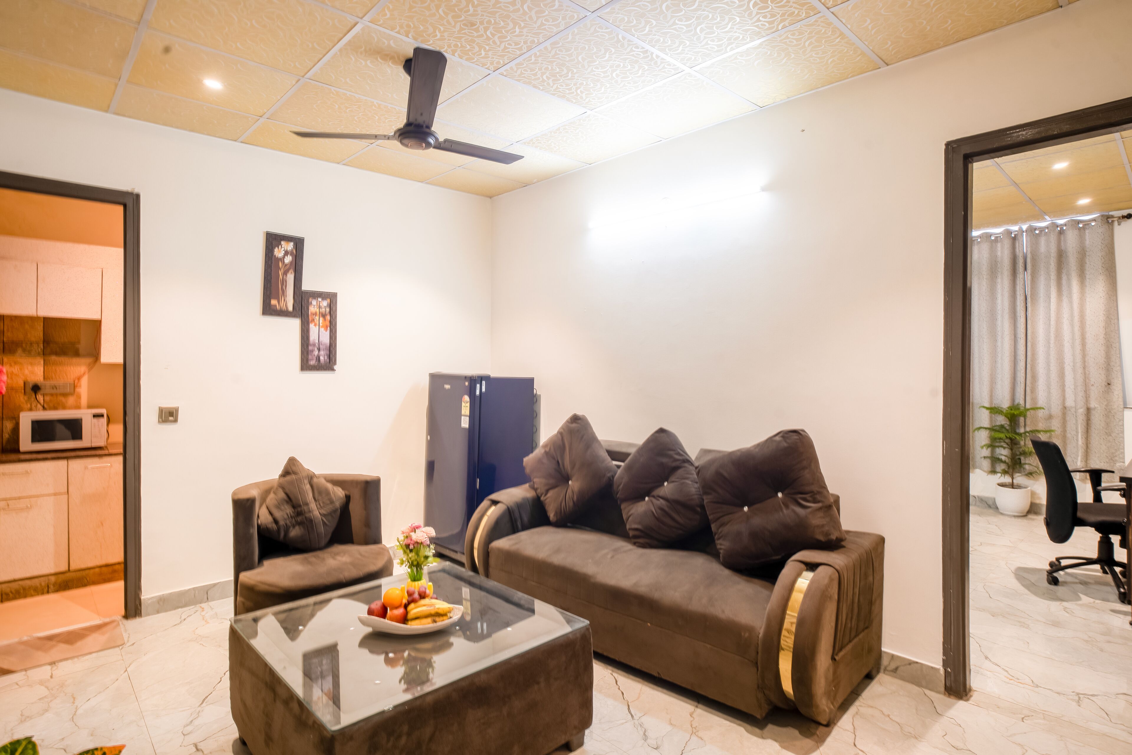 A modern living room with a sofa, a coffee table, and a ceiling fan.