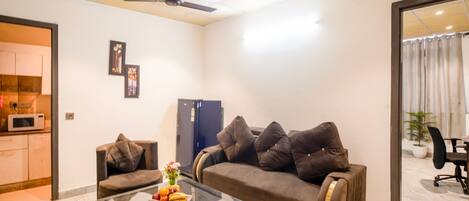 A modern living room with a sofa, a coffee table, and a ceiling fan.