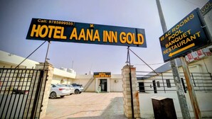 L’entrée de l’hôtel Aana Inn Gold est signalée par un panneau indiquant la présence d’une piscine, d’une salle de réception et d’un restaurant.