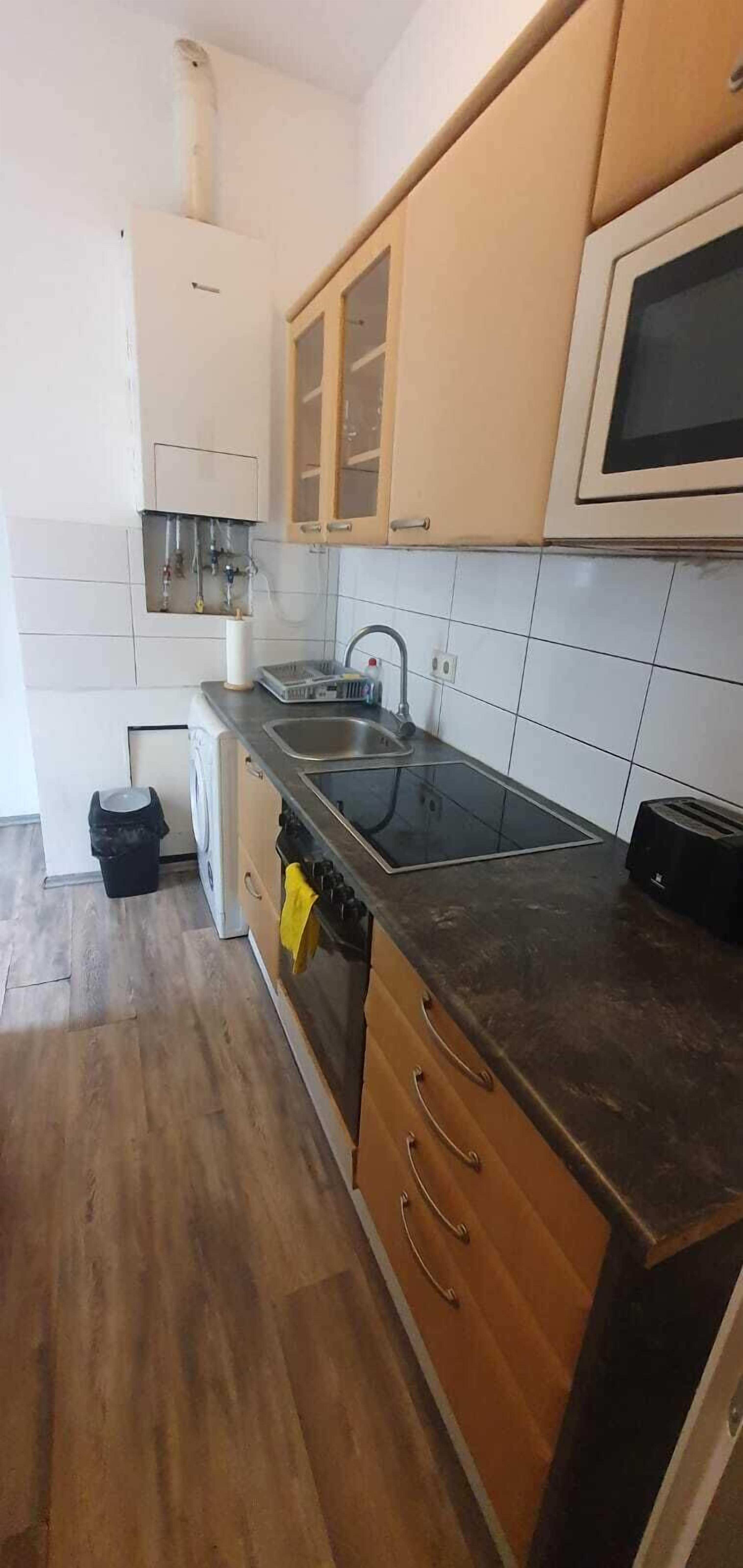 Eenvoudig appartement | Privékeuken | Een oven, een kookplaat, kookgerei, borden en bestek