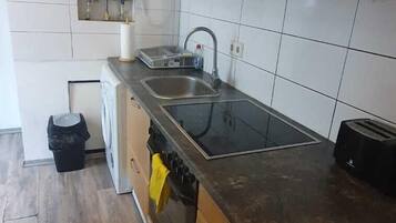 Eenvoudig appartement | Privékeuken | Een oven, een kookplaat, kookgerei, borden en bestek