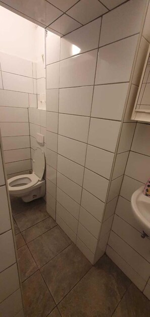 Eenvoudig appartement | Badkamer | Een douche, gratis toiletartikelen, een haardroger, handdoeken