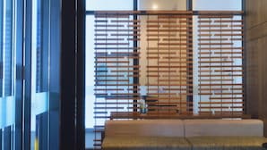 Un interior moderno con un separador de madera, un banco y una pared de vidrio con vistas.