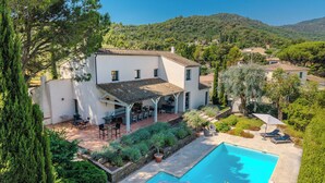 Une villa avec piscine, un espace salon extérieur et un jardin.