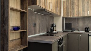A modern kitchen with wooden cabinets, a built-in oven, and a coffee machine. - Apartment 8 (Lovech)