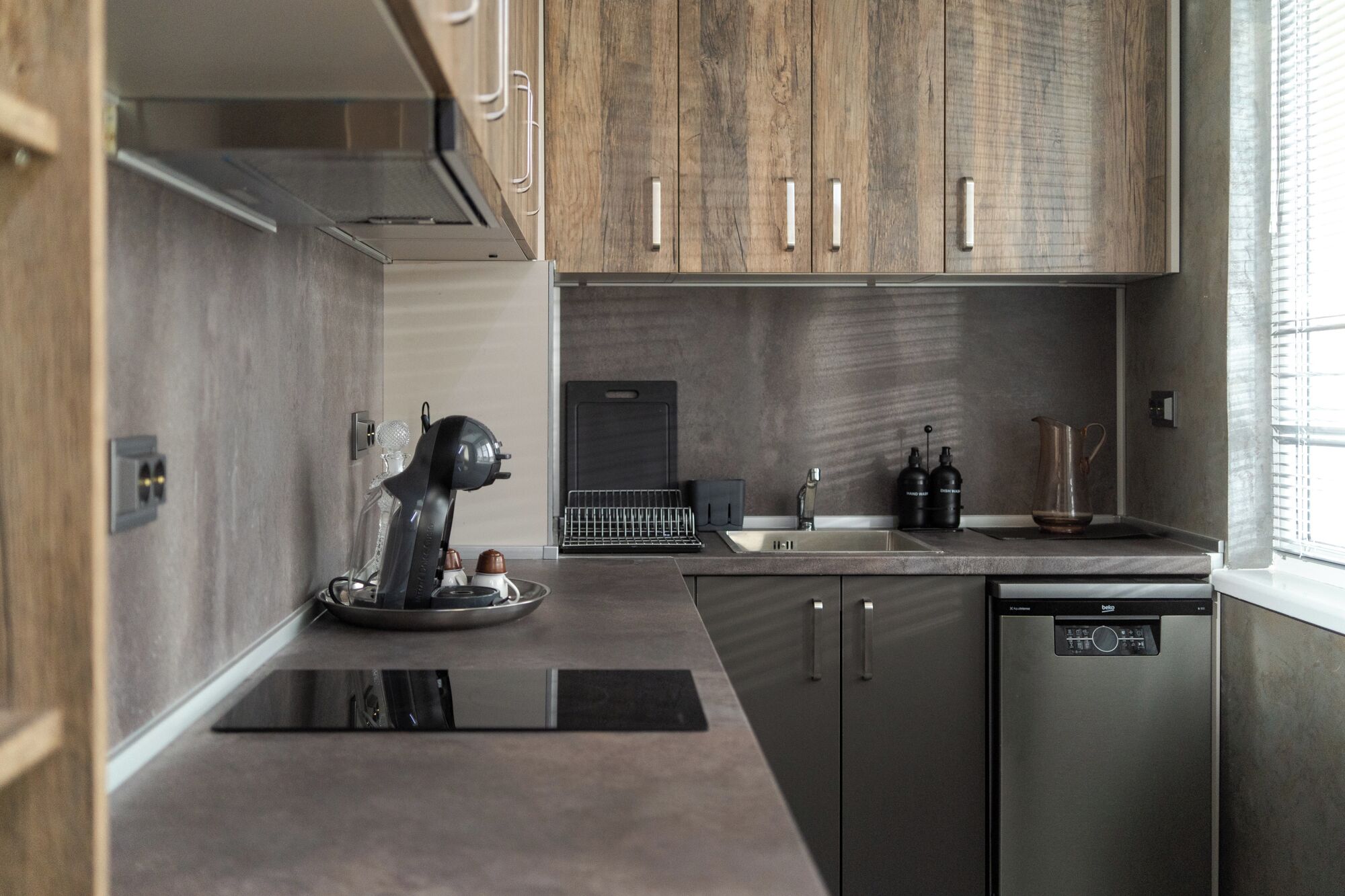 Una cocina moderna con armarios de madera, lavavajillas y cafetera.