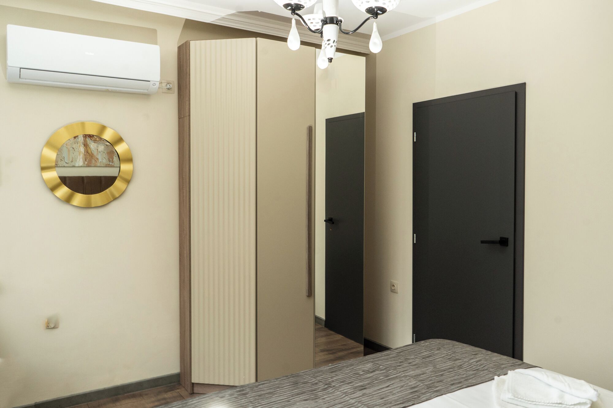 Ein Schlafzimmer mit Bett, Kleiderschrank, Spiegel und Tür.